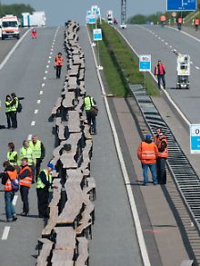 Bei der Generalprobe: Tischreihe bis zum Horizont auf der gesperrten Autobahn A540 bei Grevenbroich.