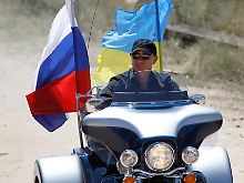 Demonstrative Verbundenheit: Putin knattert mit den Fahnen Russlands und der Ukraine.