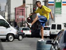 Ballkünstler im Großstadtverkehr: Jongleur auf einer Straße in Sao Paulo.