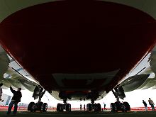 Perspektivisch über den Wolken: Besucher der Luftfahrtausstellung ILA beäugen den mächtigen Bauch eines A380 aus der Nähe (Archivbild).