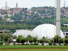 Hinterm Acker erhitzt Kernenergie Wasser, der Dampf treibt den Generator, und der erzeugt Strom: Das Kernkraftwerk Neckarwestheim mit der namensgebenden Ortschaft im Hintergrund.