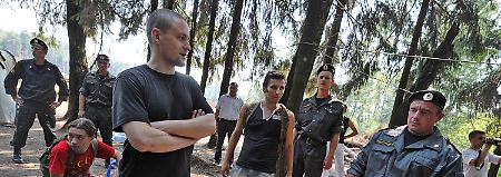 Sergei Udaltsov von einer linken Jugendbewegung unterhält sich im Wald von Chimki mit Polizisten. Der Wald soll abgeholzt werden damit die gebührenpflichtige Autobahn Moskau - St. Petersburg errichtet werden kann.