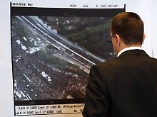 Am Rande der Sondersitzung blickt ein Mann auf Luftbilder des Loveparade-Geländes.