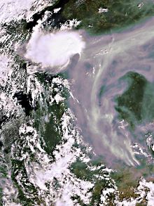 Auch auf Satellitenbildern sind die Folgen des Brandes (dunklere Wolken, rechts) deutlich zu sehen.