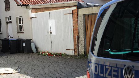 Blumen und Kerzen liegen vor einer Garage im niedersächsischen Delligsen, in der die Leiche des fünfjährigen Julian gefunden wurde.