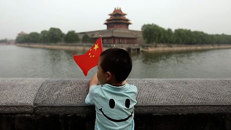 Ein Junge mit einer chinesischen Flagge steht vor der Verbotenen Stadt in Peking.