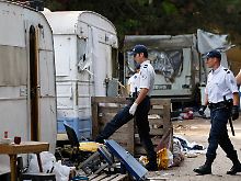 Polizisten durchsuchen ein Roma-Lager.