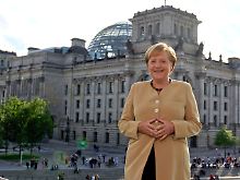 Merkel zeigt sich staatsmännisch vor dem Reichstag in Berlin.