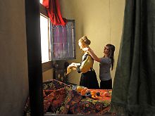 Die Figurine des "Brieflesenden Mädchens am offenen Fenster" in einem maßstabgerechten Nachbau des Gemäldes wird nochmal gerichtet.