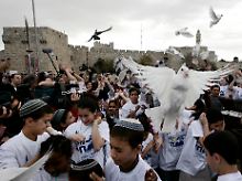 Jüdische und muslimische Kinder lassen am Jaffa-Tor in Jerusalem Friedenstauben fliegen.