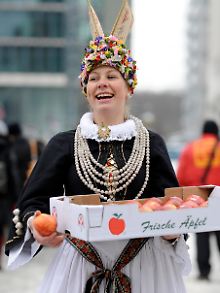 Die Altländer Blumenkönigin Rebecca Rieper verteilz auf dem Potsdamer Platz in Berlin Äpfel. 