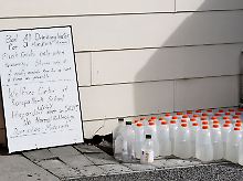 Trinkwasserflaschen in der Stadt Kaiapoi nahe Christchurch. Das Schild weist darauf hin, dass die Bürger sparsam mit Wasser umgehen und es vor dem Trinken abkochen sollen.