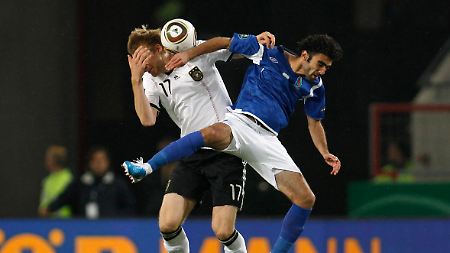 Schmerzhafter Augenblick für Per Mertesacker: Sein Gegenspieler Javadof rammt dem Bremer den Arm ins Gesicht.