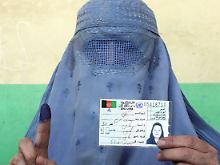 Eine Afghanin zeigt ihre Registrierung als Wählerin und ihren gefärbten Finger - sie hat ihre Stimme schon abgegeben.