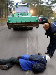 Eine Polizistin bemüht sich, eine Ein-Mann-Blockade aufzulösen.
