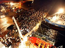 Im Hafen von Bengasi wollen Hunderte an Bord eines türkisches Schiffes.