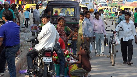 Verhältnis von 113 zu 100: Männer und Frauen auf einer Straße in Deu Delhi, Indien.