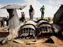 Libyer begutachten das Wrack der F15, die bei Bengasi abgestürzt ist.