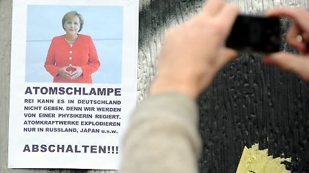 Am Rande der Demonstration in Berlin sorgt ein Plakat für Aufmerksamkeit.