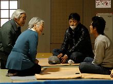 Japans Kaiser mit seiner Frau besucht Opfer der Katastrophe in einem Flüchtlingslager. 