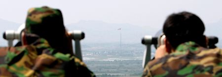 Zwei südkoreanische Soldaten beobachten von einem Grenzposten die Aktivitäten auf Nordkoreas.