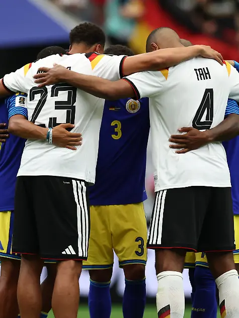 Fussball-Maenner-WM-Deutschland-Curacao-Vorrunde-Gruppe-E-1-Spieltag-Houston-Stadion-Felix-Nmecha-Deutschland-und-Jonathan-Tah-Deutschland-umarmen-Spieler-aus-Curacao-ACHTUNG-Gemaess-den-Auflagen-der-FIFA-duerfen-die-Bilder-ausschliesslich-zur-redaktionellen-Verwendung-genutzt-werden-Eine-kommerzielle-Nutzung-ist-ausgeschlossen-Zudem-duerfen-keine-videoaehnlichen-Sequenzen-erstellt-werden-und-es-duerfen-keine-Veraenderungen-weder-im-Vordergrund-noch-im-Hintergrund-am-Bild-vorgenommen-werden