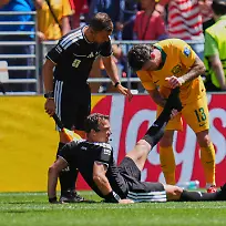 Fussball-Maenner-WM-2026-USA-Australien-Vorrunde-Gruppe-D-Spieltag-2-Seattle-Stadion-Schiedsrichter-Felix-Zwayer-Deutschland-sitzt-auf-dem-Rasen-bekommt-vom-Australier-Aiden-O-Neill-Unterstuetzung