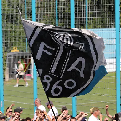 Fussball-Herren-Regionalliga-regional-league-Bayern-Saison-2026-2027-TSV-Munich-1860-Training-Fanmarsch-Auflauf-der-Ultras-EV-Anh-nger-am-Trainingsgel-nde-bei-Training-des-TSV-Munich-1860-Ges-nge-Anfeuern-Fahne-mit-dem-Logo-der-Fussballabteilung