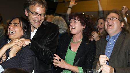 Der Fraktionsvorsitzende der Grünen im Gemeinderat Stuttgart, Werner Wölfle (links) jubelt im Rathaus der Landeshauptstadt mit anderen Parteimitgliedern.