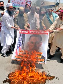 Muslime verbrennen in Pakistan ein Banner mit dem US-Präsidenten.