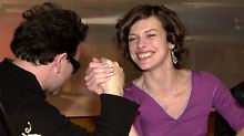 Die Schauspielerin Milla Jovovich beim Armdrücken mit U2-Sänger Bono.