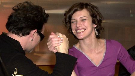 Die Schauspielerin Milla Jovovich beim Armdrücken mit U2-Sänger Bono.