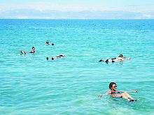 Viele Urlauber und Ausflügler kommen zum Toten Meer, um sich im stark salzhaltigen Wasser treiben zu lassen.