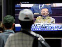 In einem U-Bahnhof in Seoul sehen Südkoreaner sich die Nachrichten an.