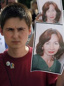 Auf einer Gedenkdemonstration in Moskau halten die Menschen Bilder der Getöteten in die Höhe.