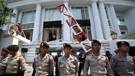 Indonesische Sicherheitskräfte vor der zerstörten Fassade des Ritz-Carlton-Hotels.