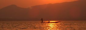 Sonnenaufgang am Inle-See: Frühmorgens sind die Fischer schon auf dem Wasser, aber von der Hektik des Tages ist noch nichts zu spüren.