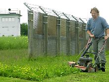 Auf dem ehemaligen Todesstreifen bei Teistungen mäht ein Mitarbeiter des Grenzlandmuseums das Gras.