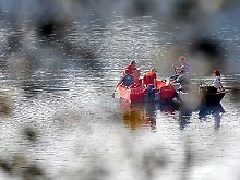 Polizei, Helfer und Taucher suchen den Kreidesee in Hemmoor nach den Vermissten ab.