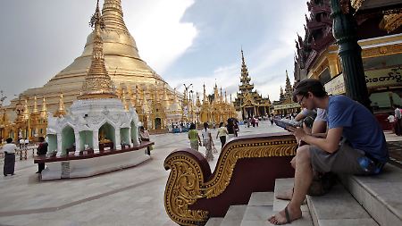 Touristen beim Reiseführer-Studium an der Shwedagon-Pagode in Yangon (Rangun).