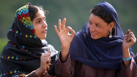 Zwei gehörlose Frauen unterhalten sich mittels Gebärdensprache in Nordindien. 