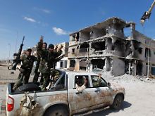 Kämpfer in Sirte jubeln in den Trümmern.