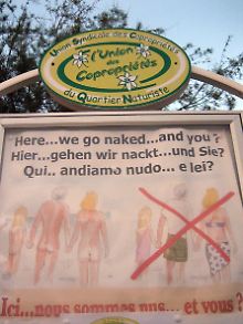 Das Schild am Eingang der Anlage in Cap d'Agde fordert Besucher in verschiedenen Sprachen auf, ihre Kleidung abzulegen.