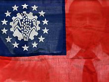 Ein Student, der die Flagge Birmas hochhält.
