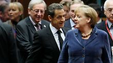 Kanzlerin Merkel schreitet voran, Frankreichs Präsident Sarkozy folgt ihr.