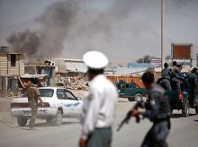 Afghanische Einsatzkräfte nähern sich der Straße, an der ein Attentäter sich und sein Auto in die Luft sprengte.