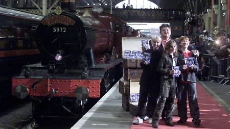 Darsteller aus "Harry Potter" neben dem Hogwarts-Express auf dem Bahnhof King's Cross (Tom Felton, Robbie Coltrane, Emma Watson und Rupert Grint, v.l.) (Archivbild von 2002)