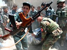 Polizisten bergen eine Toten, der bei einer Schießerei in Kabul ums Leben gekommen ist.