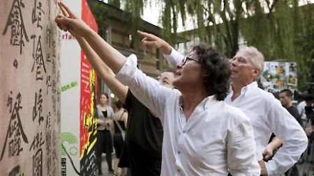 Der chinesische Künstler Xu Bing erklärt dem deutschen Botschafter in Peking, Michael Schaefer, seinen "Mauerstein".