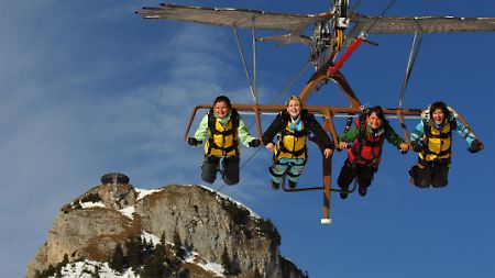 Wagemutige liegen in einer riesigen Seilrutsche, dem Airrofan, und rasen den Gschöllkopf im Rofangebirge am Achensee (Österreich) hinab.